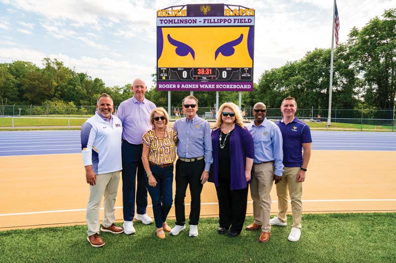 PICTURED (L TO R) standing in front of the Roger & Agnes Ware Scoreboard are Vice President of University Affairs and Chief of Staff Andrew Lehman, Director of Athletics Terry Beattie, Agnes Ware, Roger Ware ’82, West Chester University President Dr. Laurie Bernotsky, Vice President for University Advancement and External Affairs Dr. Zebulun Davenport, and President of Commonwealth University Dr. Jeffery Osgood, Jr.