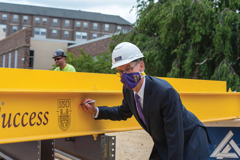 Chris Fiorentino signing his name to a beam that is to be placed into the SECC building.