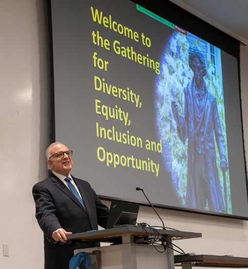 Former Senator Andy Dinniman is pictured addressing those attending the first Annual Community Gathering held at West Chester University in the spring of 2023. Dinniman is pictured standing next to a photo of Frederick Douglass, the great abolitionist, orator and statesman.