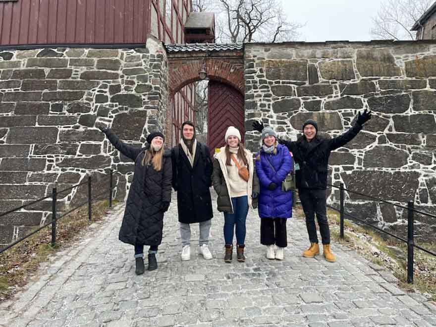 Group posing outside of brick building