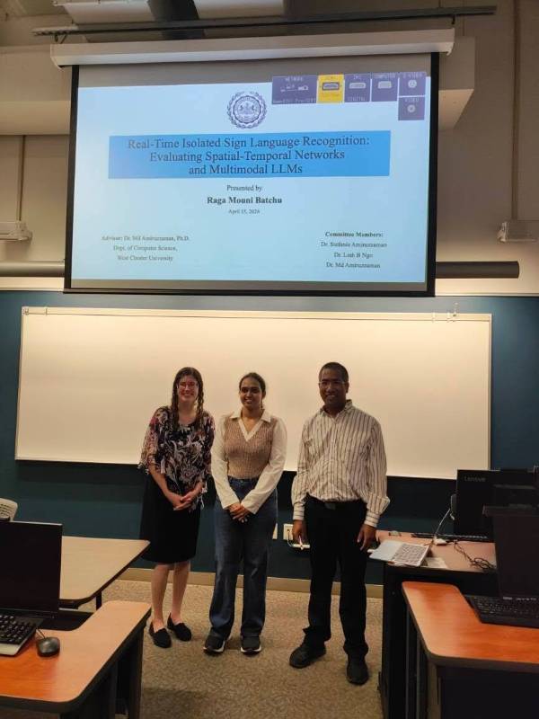 Student with advisors in front oof projector with her thesis title