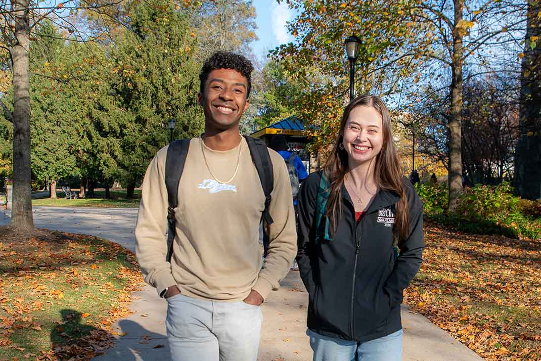 
						 Two students smiling. 
					