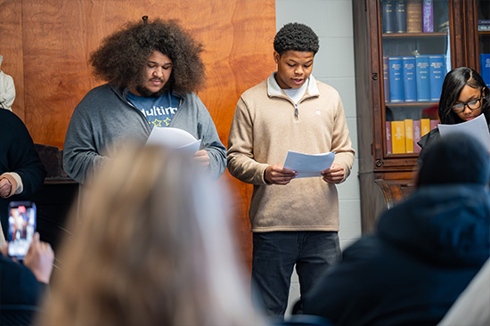 Candid photo from the Frederick Douglass day event. Students reading a script.