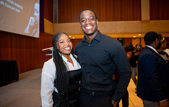 A male and female posing for picture at the society event