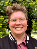 portrait of a white person with short hair smiling at camera